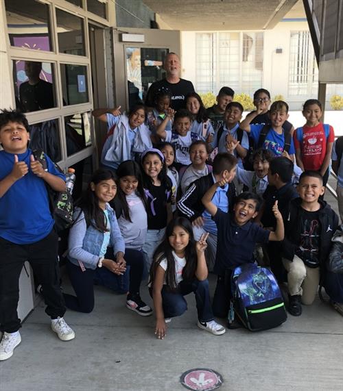 lots of children smiling with male adult